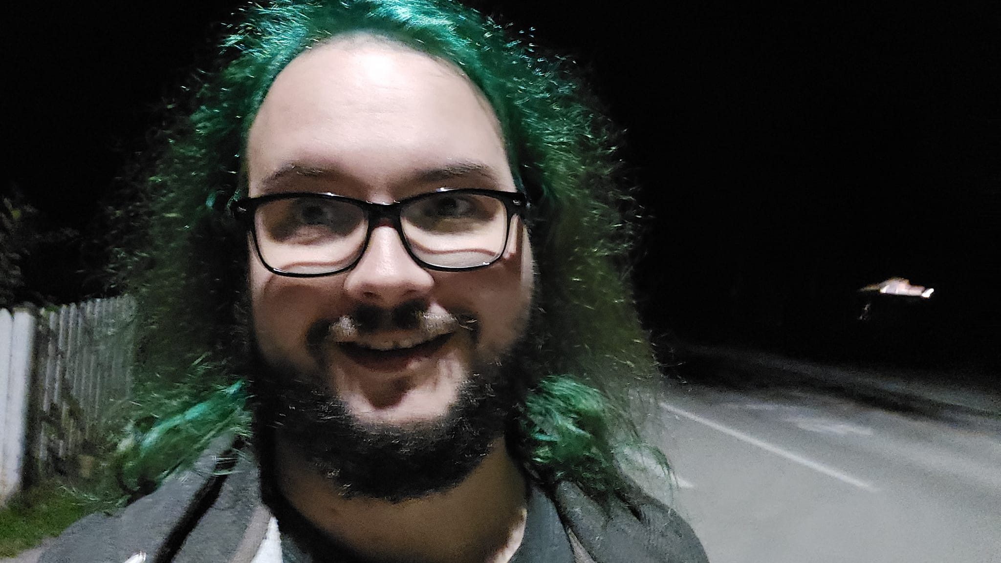 A man with green hair is outside after dark, Photo 14